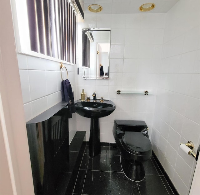 bathroom with tile patterned flooring, tile walls, and toilet