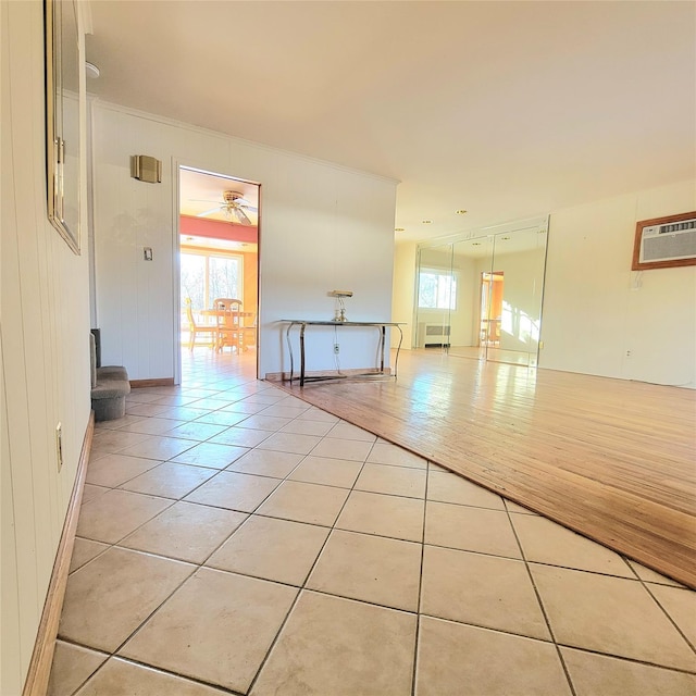 tiled spare room featuring radiator heating unit and an AC wall unit