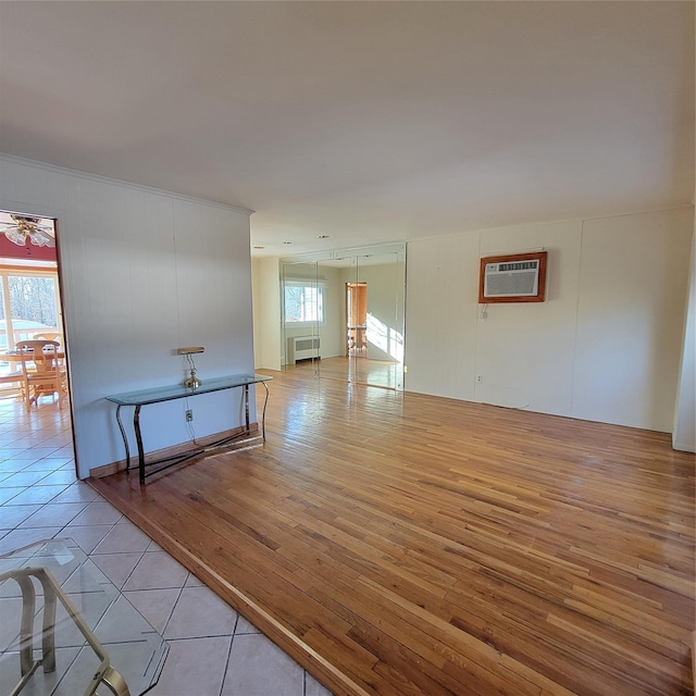 tiled empty room with an AC wall unit and ceiling fan