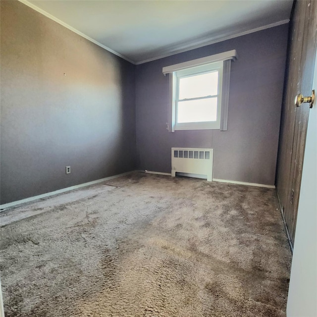 spare room with crown molding, radiator, and carpet flooring