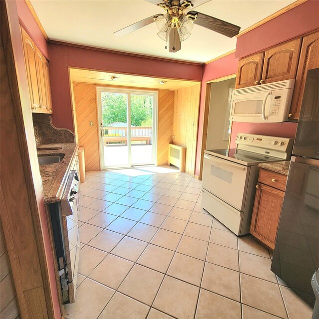 3914 Jerusalem Ave, Seaford, NY 11783 - kitchen featuring white appliances, light tile patterned flooring, ceiling fan, dark stone countertops, and wooden walls