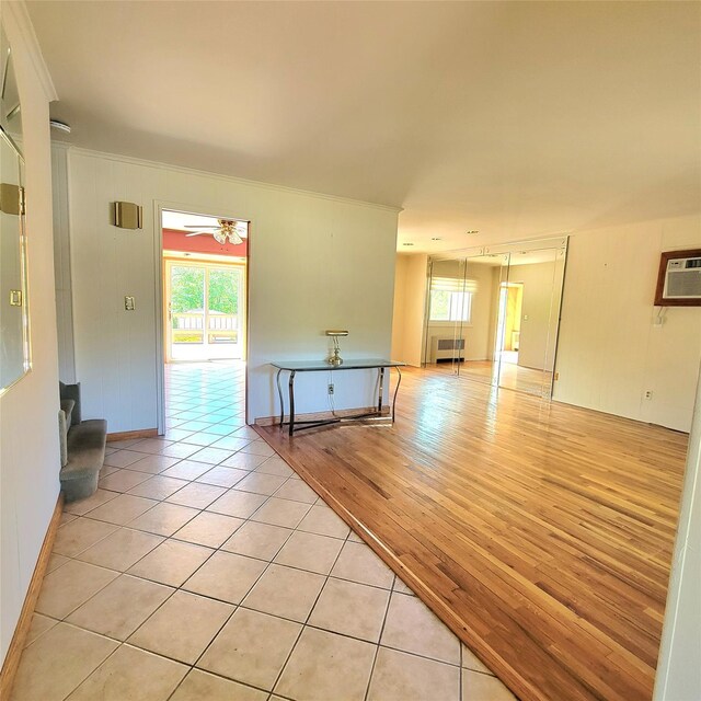 3914 Jerusalem Ave, Seaford, NY 11783 - empty room with crown molding, light tile patterned floors, an AC wall unit, baseboards, and radiator