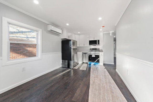 kitchen featuring white cabinetry, an AC wall unit, ornamental molding, appliances with stainless steel finishes, and dark hardwood / wood-style flooring