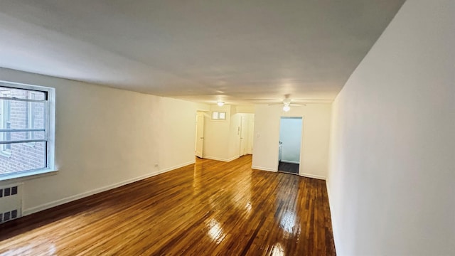 spare room with hardwood / wood-style floors and radiator heating unit