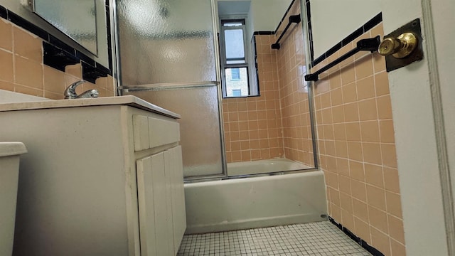 bathroom with tile patterned floors, tile walls, and enclosed tub / shower combo