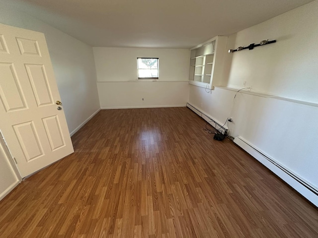 empty room featuring a baseboard radiator and hardwood / wood-style flooring