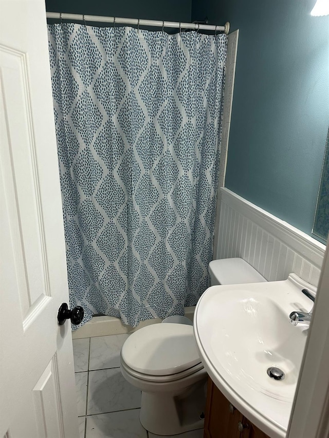 bathroom featuring curtained shower, toilet, and sink