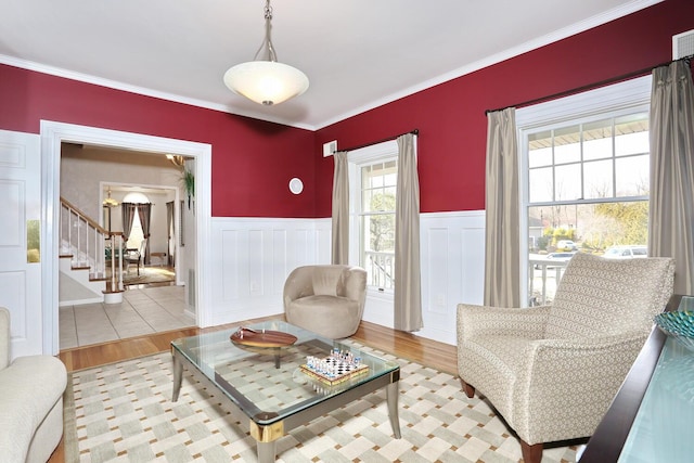 sitting room with light wood-type flooring and ornamental molding