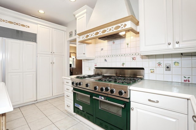 kitchen featuring premium range hood, range with two ovens, and white cabinets