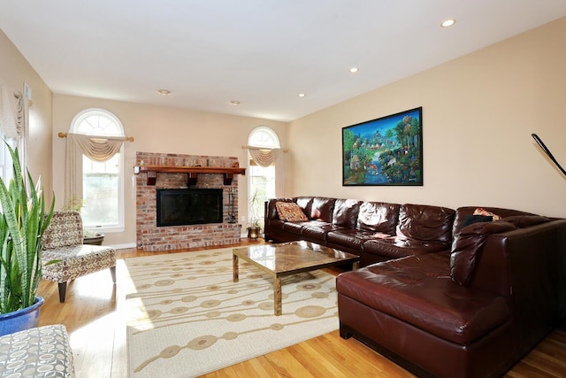 living room with a fireplace, plenty of natural light, and light hardwood / wood-style flooring