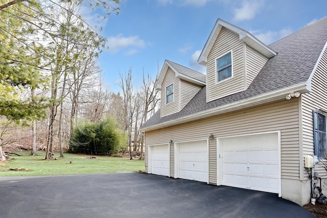 view of side of home with a yard and a garage