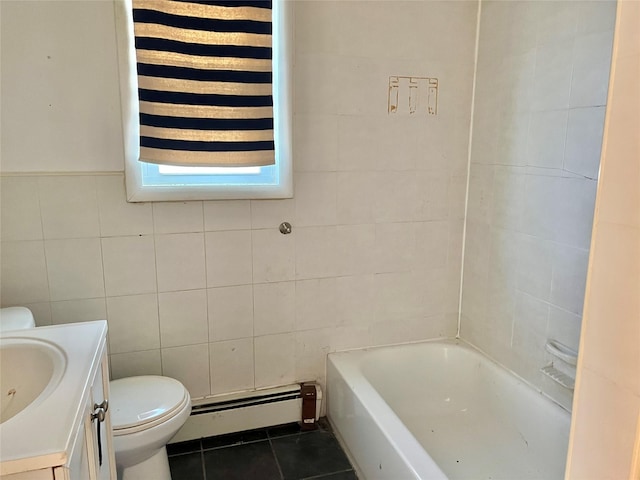 bathroom featuring tile patterned flooring, a baseboard heating unit, a tub to relax in, vanity, and tile walls