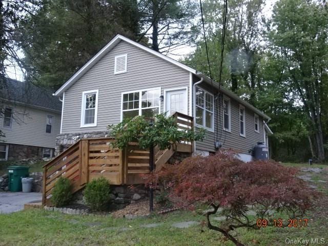 rear view of property featuring a wooden deck