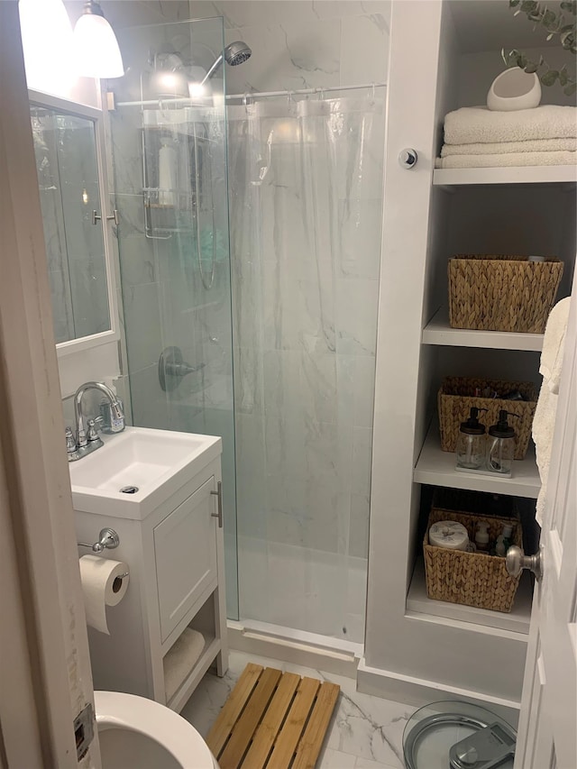 bathroom with a stall shower, marble finish floor, and vanity