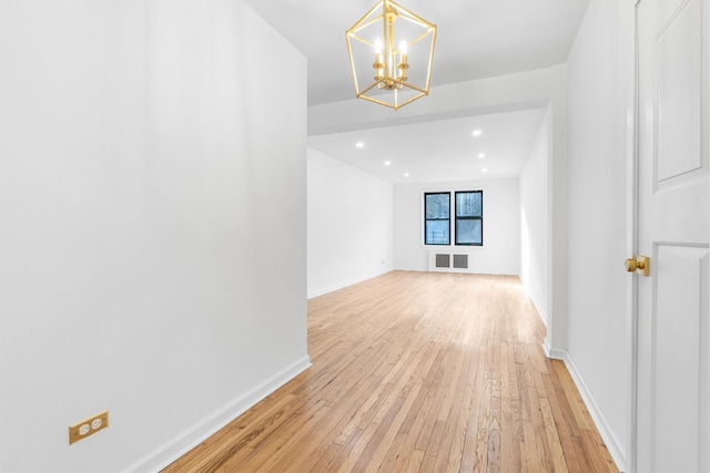 unfurnished living room with a chandelier and light hardwood / wood-style flooring