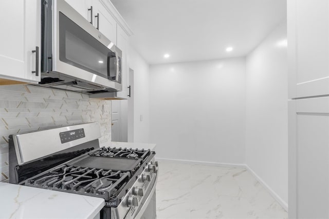 kitchen featuring white cabinets, decorative backsplash, light stone counters, and stainless steel appliances