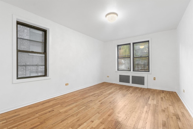 spare room with radiator and light hardwood / wood-style flooring