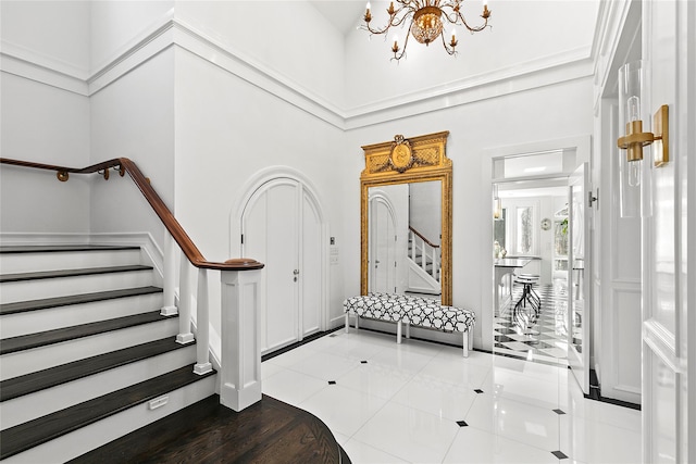 foyer featuring light tile patterned floors, a high ceiling, and a notable chandelier