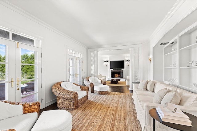 living room with wood-type flooring, crown molding, and french doors