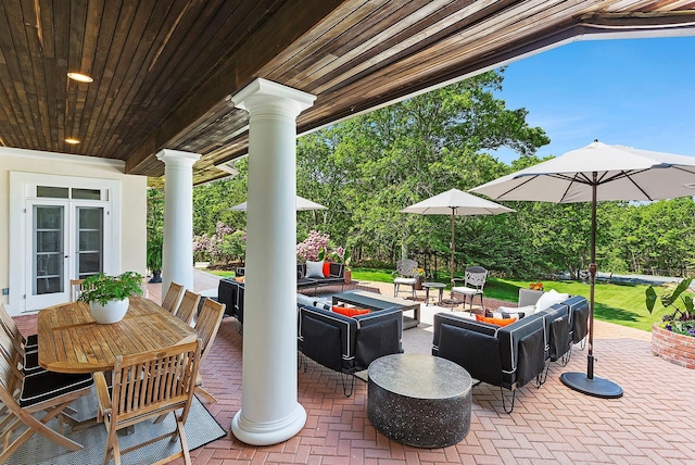 view of patio with an outdoor living space with a fire pit and french doors