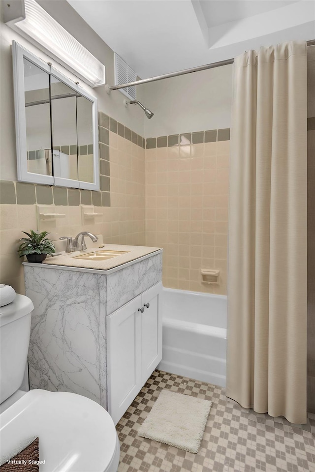 full bathroom featuring vanity, toilet, shower / bathtub combination with curtain, tile walls, and tasteful backsplash