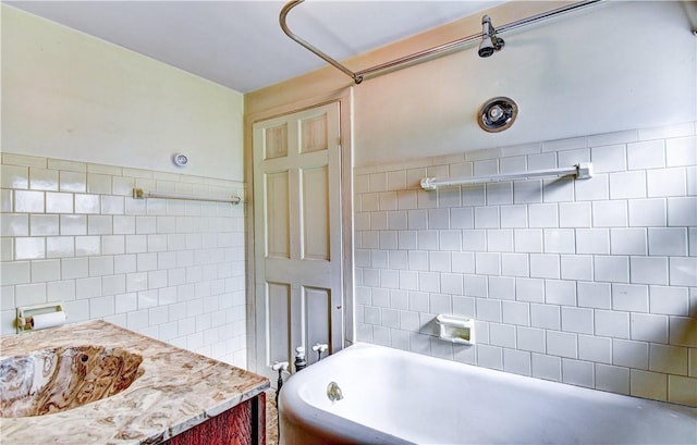 bathroom with vanity and tile walls