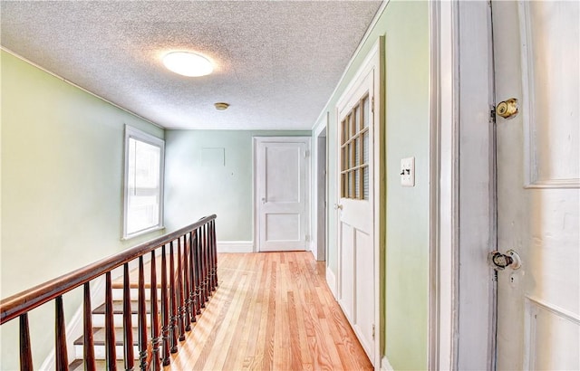 hallway featuring a textured ceiling and light wood-type flooring