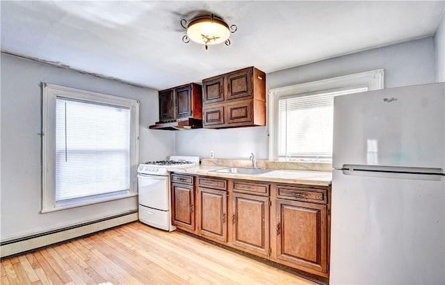 kitchen with light wood-type flooring, white range, baseboard heating, sink, and stainless steel refrigerator