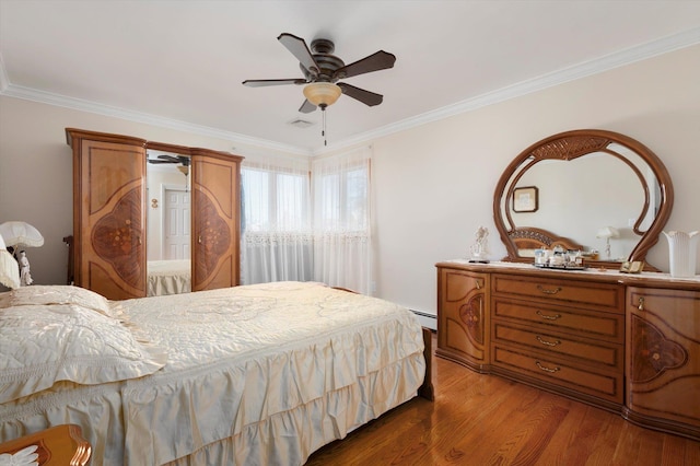 bedroom featuring ceiling fan, ornamental molding, and hardwood / wood-style flooring