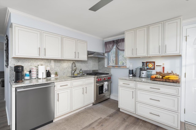 kitchen featuring crown molding, sink, wall chimney exhaust hood, appliances with stainless steel finishes, and white cabinetry