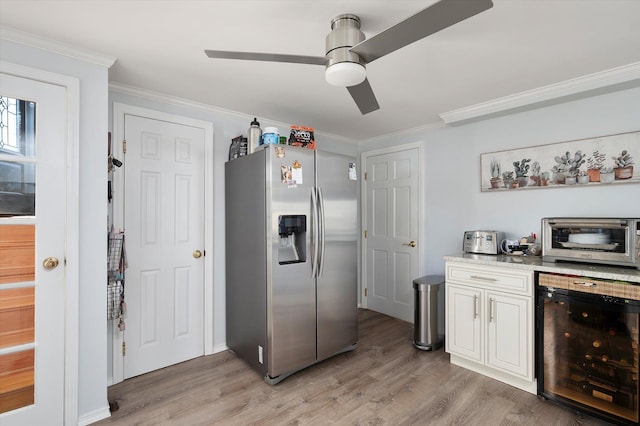 kitchen featuring light hardwood / wood-style flooring, ceiling fan, stainless steel fridge, ornamental molding, and beverage cooler