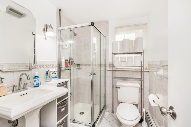 bathroom with a baseboard heating unit, sink, toilet, tile walls, and walk in shower