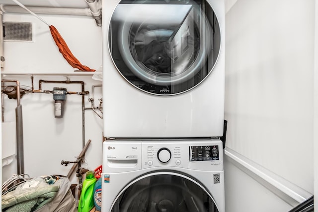 clothes washing area with stacked washer and clothes dryer