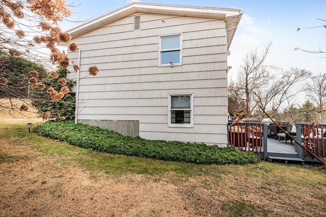 view of side of home featuring a yard and a deck