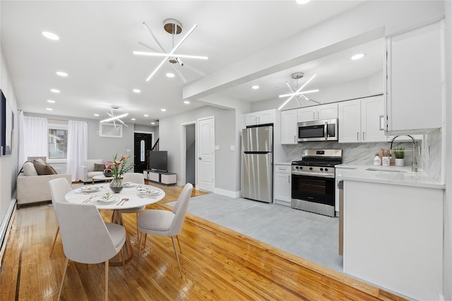 kitchen featuring light hardwood / wood-style flooring, sink, stainless steel appliances, and a chandelier