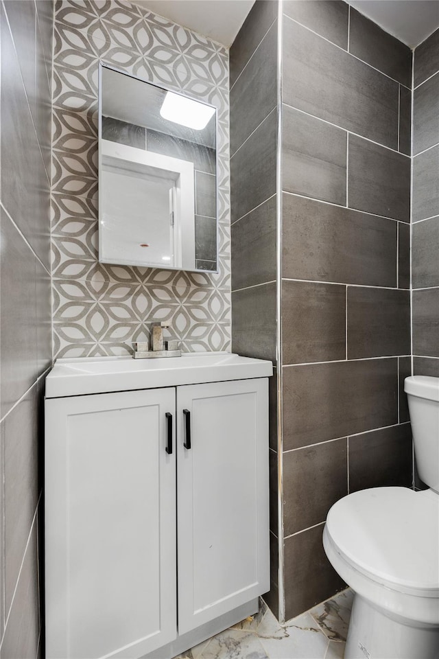 bathroom featuring backsplash, vanity, tile walls, and toilet