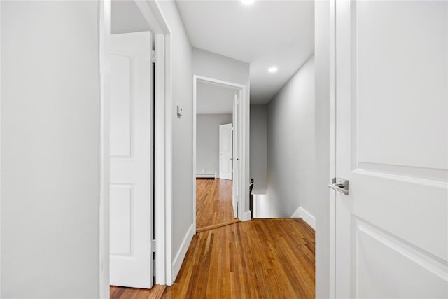 hall with wood-type flooring and a baseboard radiator