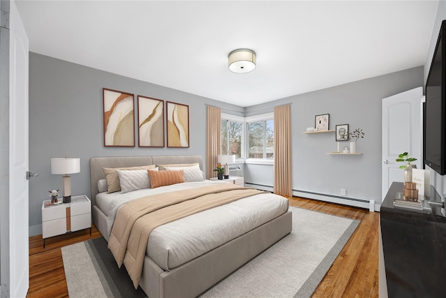 bedroom with a baseboard radiator and wood-type flooring