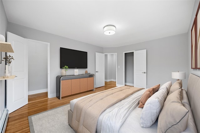 bedroom featuring baseboard heating and hardwood / wood-style flooring