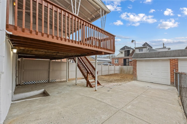 view of patio with an outbuilding, a garage, and a wooden deck