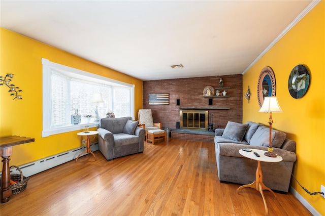 living room featuring a brick fireplace, light hardwood / wood-style floors, ornamental molding, and baseboard heating