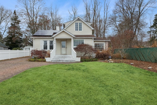 view of front of house with solar panels and a front yard