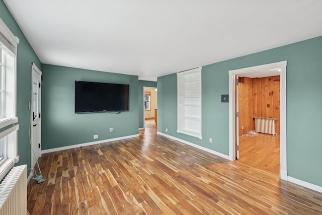 unfurnished living room featuring wood-type flooring and radiator