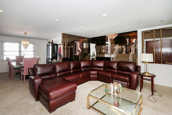 carpeted living room featuring a chandelier