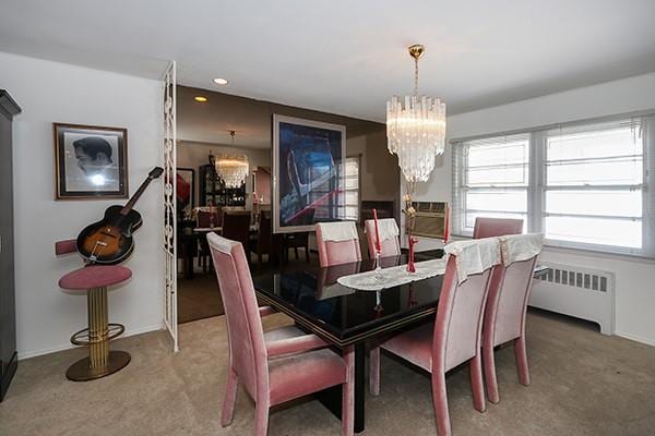 dining room featuring carpet flooring, a notable chandelier, cooling unit, and radiator