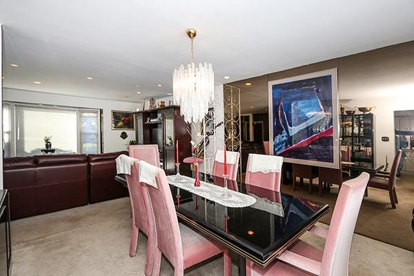 dining area with carpet and a notable chandelier