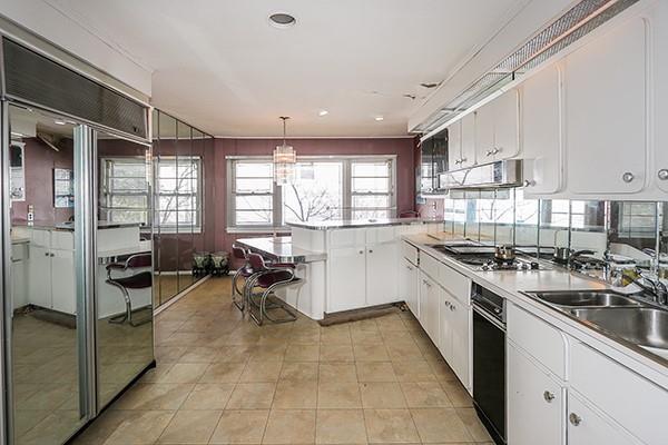 kitchen featuring extractor fan, white cabinetry, hanging light fixtures, and stainless steel gas cooktop