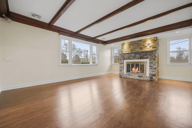 unfurnished living room with hardwood / wood-style floors, beam ceiling, and a fireplace