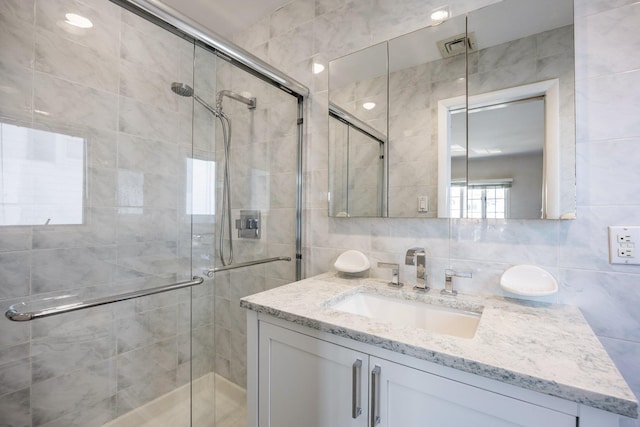 bathroom with tasteful backsplash, tile walls, and a shower with door