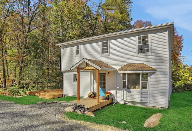 view of front of home featuring a wooden deck and a front lawn